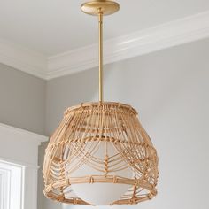 a light that is hanging from the ceiling in a room with white walls and wood flooring