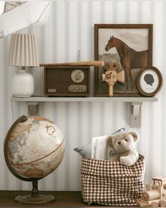 a teddy bear is sitting on a chair in front of a wall with striped walls