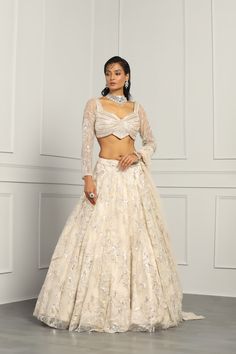 This Lehenga Choli is Ready to Wear Ivory attached cancan lehenga with sequin, floral embroidery. Paired with a padded blouse with all over beads, sequins, cutdana work and dupatta. No of Components: 3 Components: Blouse, Dupatta, Lehenga Pattern: Embroidery Type of Work: Cutdana, Sequins, Beads Neckline: Asymmetric Neck Sleeve Type: Full Sleeves Fabric: Net Color: Ivory Other Details: Attached inner lining Lehenga Length: 46 inches Blouse Chest : 38 Occasion: Bride, Destination Wedding Disclaim Party Wear Floor-length Lehenga With Pearl Embroidery, Party Wear Festive Lehenga With Pearl Embroidery, Off White Anarkali Lehenga With Floral Embroidery, Festive Off White Lehenga With Floral Embroidery, Fitted Lehenga With Pearl Embroidery For Navratri, Festive Cream Choli With Pearl Embroidery, Party Wear Sets With Floral Embroidery For Wedding, Fitted Cream Lehenga For Diwali, Cream Fitted Lehenga For Diwali