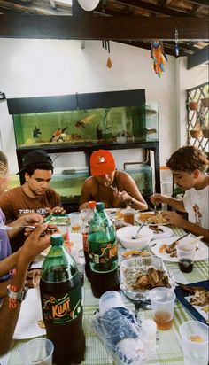 four people sitting at a table with food and drinks