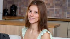 a woman sitting on a couch smiling at the camera