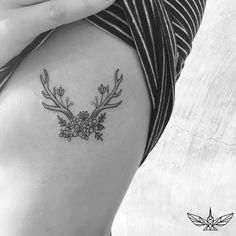 a black and white photo of a woman's thigh with flowers on it,