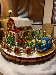 a christmas scene with a toy truck and farm in the snow on top of a table