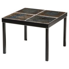 a square table with black and brown tiles on it's sides, against a white background