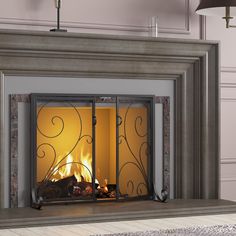 a fireplace with a fire burning in it's mantle and ornate iron work on the doors