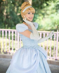 a woman in a blue dress and white gloves