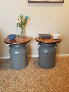 two round tables sitting next to each other on top of a carpeted floor in front of a wall