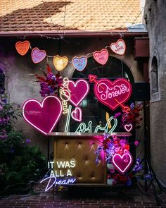 neon signs and flowers adorn the front of a building