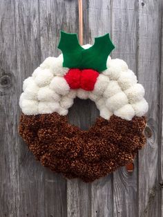 a christmas wreath hanging on the side of a wooden fence