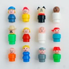 many different colored plastic toy people on a white surface