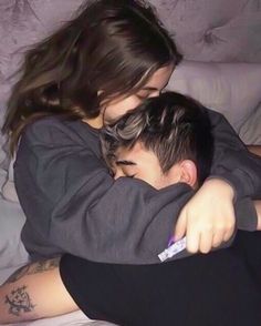 a man and woman cuddling on top of each other