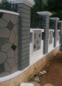 a row of windows on the side of a building next to a stone wall and fence