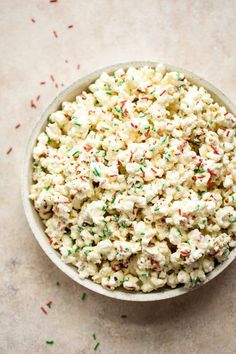 a bowl filled with white and green sprinkles on top of a table