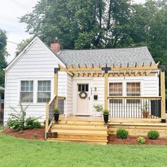 a small white house with steps leading to the front door