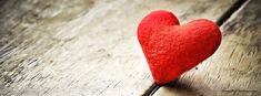 a red heart sitting on top of a wooden table