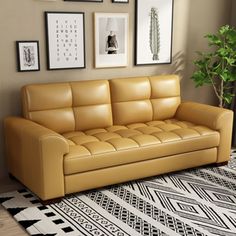 a tan leather couch sitting on top of a black and white rug