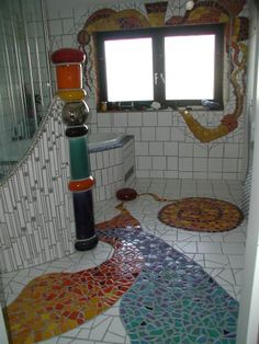 a bathroom with colorful tiles on the floor and walls, along with a window in the corner