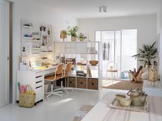 a white room with lots of furniture and plants on the desk in front of it