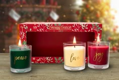 three candles are sitting in front of a red box with the word love on it