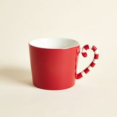 a red and white coffee cup with candy canes in the shape of a heart