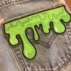 a pair of jeans with green paint on them