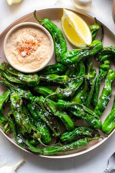 a white plate topped with asparagus covered in powdered sugar next to a lemon wedge