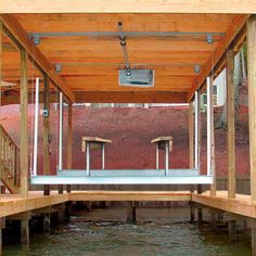 the inside of a covered boat dock with two benches on each side and one bench in the middle