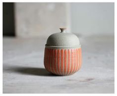 an orange and white striped ceramic container