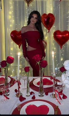 a woman standing in front of a table set for valentine's day