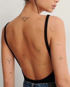 the back of a woman with tattoos on her upper and lower back, showing different symbols