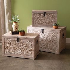 three wooden boxes sitting on top of each other in front of a green painted wall