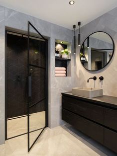 a bathroom with a sink, mirror and shower stall in the corner next to it