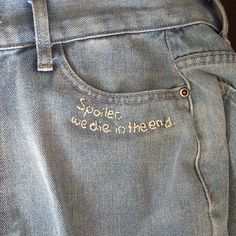 the back pocket of a pair of jeans with embroidered words on them