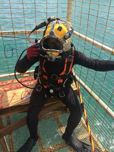 a man in scuba gear standing on the side of a boat