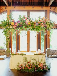 a table with flowers and candles on it in front of a window filled with windows