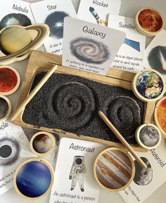 an assortment of different planets and their names in wooden trays on top of cards