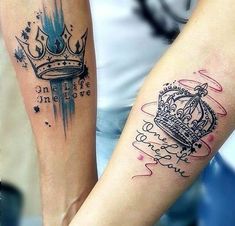 two people with tattoos on their arms holding each other's hands and one has a crown