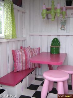 a pink table and bench in a room with black and white checkered flooring