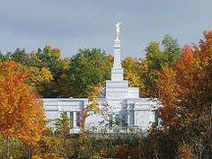 a white building surrounded by trees in the fall