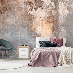 a bedroom with a concrete wall and white rugs on the floor next to a bed