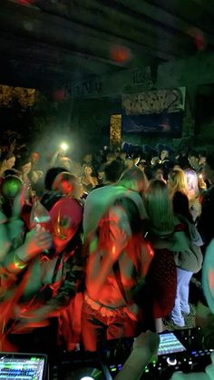 a group of people standing around each other in front of a dj's mixer