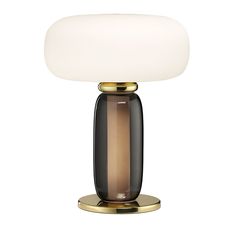 a table lamp with a white light on it's base and a black glass shade