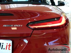 the back end of a red sports car in a showroom with its license plate