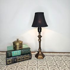 a lamp sitting on top of a table next to two books and a teapot