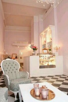 the pink bakery interior is decorated in pastel colors and features an antique chair with tufted arms