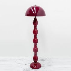 a red lamp sitting on top of a white table