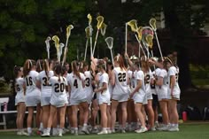 a group of girls lacrosse players huddle together