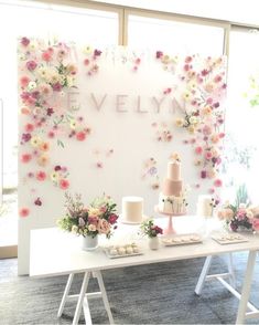 a table topped with cakes and flowers on top of a white table covered in frosting