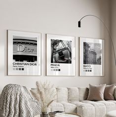 a living room filled with white furniture and pictures on the wall above it's coffee table