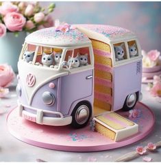 a cake shaped like a bus with cats on top